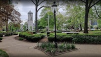 a view of a park with a clock tower in the background